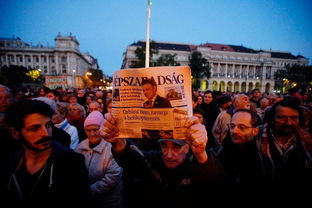 A man holds up the  last printed edition of Népszabadság during a 2016 demonstration organized to express solidarity with the Hungarian political daily newspaper in Budapest