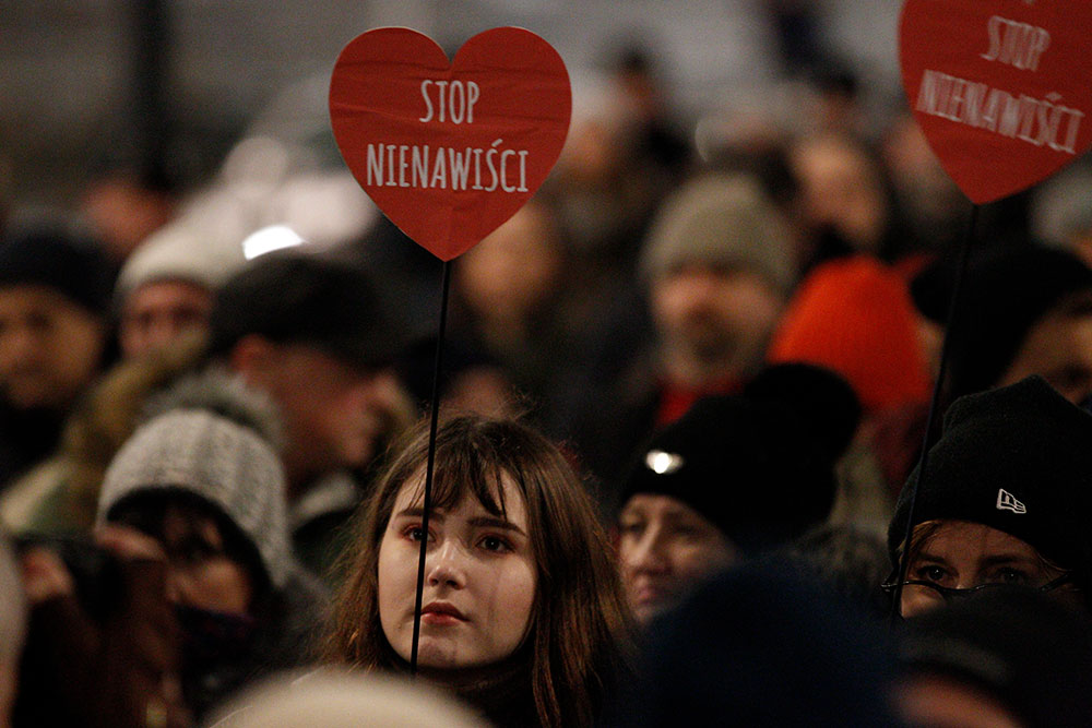 Holding a sign reading “stop hate,” a woman is among hundreds gathered in front of state-owned TVP’s headquarters in Warsaw, Poland in January, protesting what they consider biased broadcasting