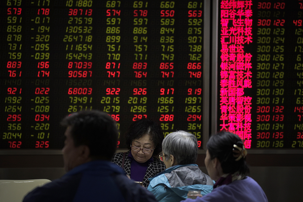 Investors monitor share prices at a brokerage house in Beijing, in March 2019