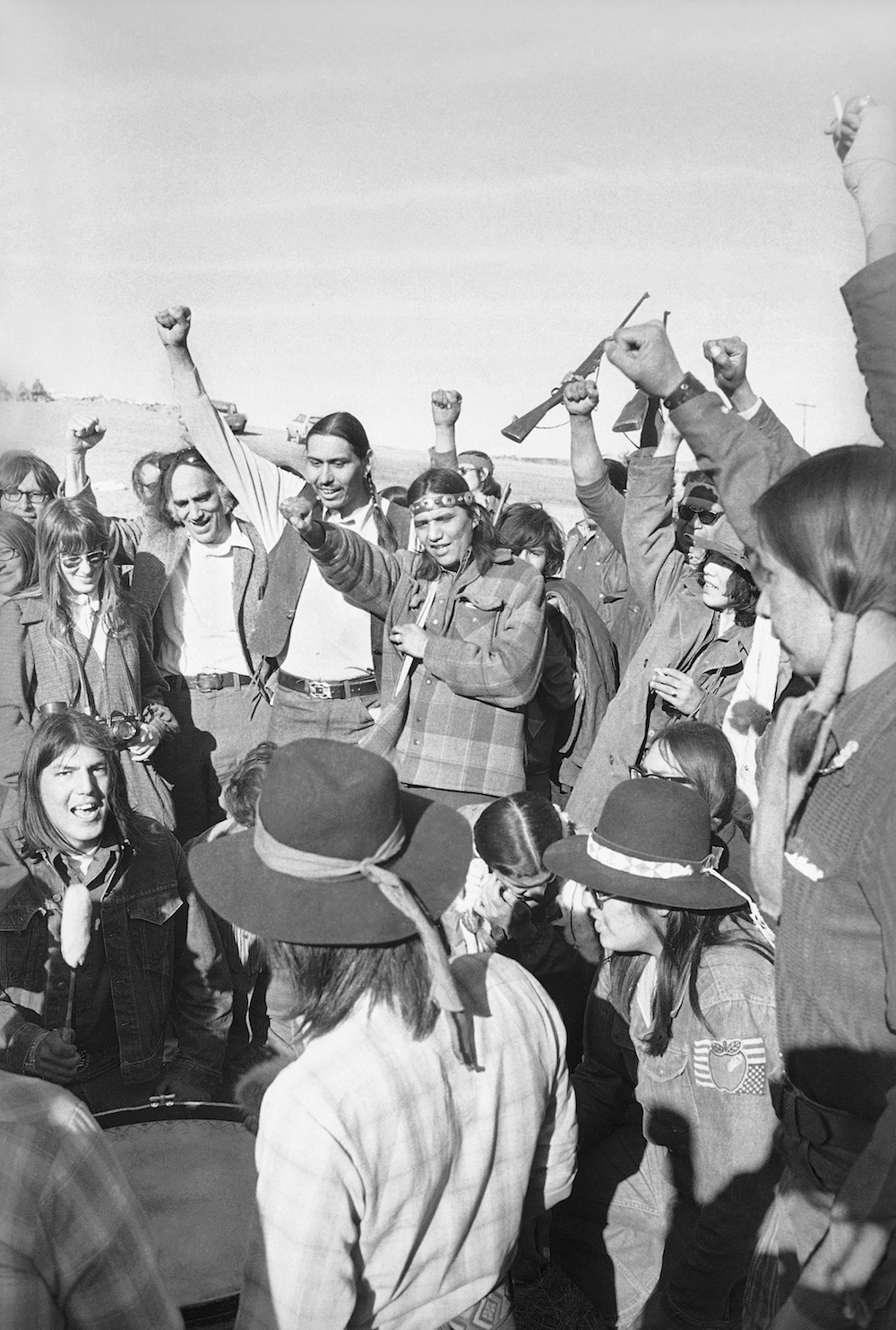 American Indian Movement (AIM) members and supporters celebrate the pullout of federal lawmen from roadblocks in Wounded Knee, South Dakota, on March 10, 1973. Federal forces surrounded Wounded Knee for over a week following AIM's takeover of the town