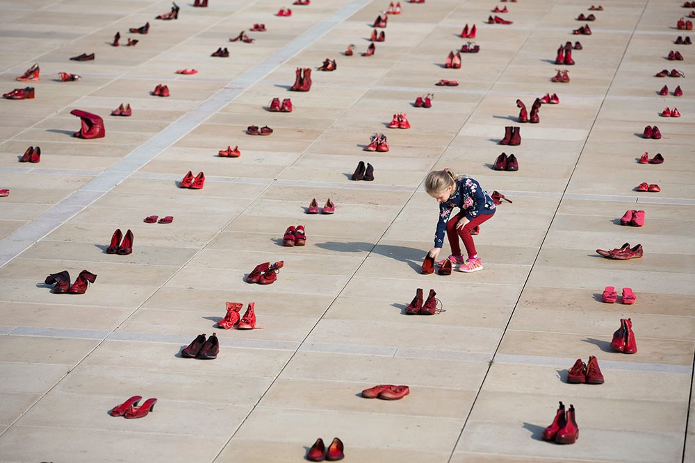 Hundreds of red shoes representing victims of domestic violence are spread across Habima Square in Tel Aviv, Israel in 2018 as part of a nationwide strike in protest of violence against women
