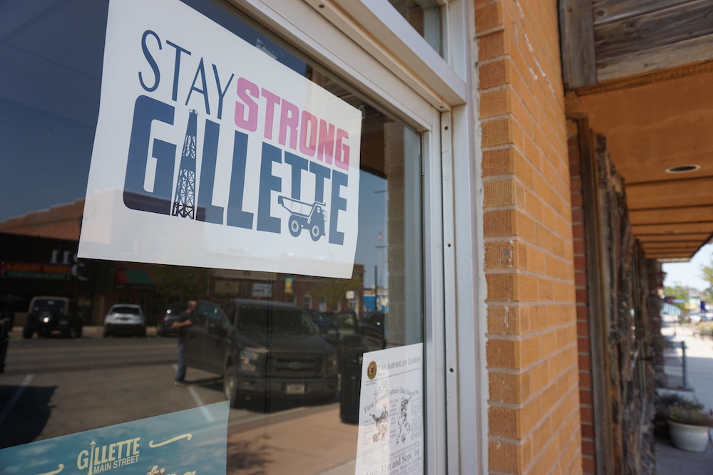 A poster displayed in a Gillette storefront urges locals to stay strong amid economic hardship following the shutdown of Blackjewel LLC's Belle Ayr and Eagle Butte mines in 2019. Once ripe with well-paid blue-collar jobs, Gillette has been hard hit by the coal industry’s decline