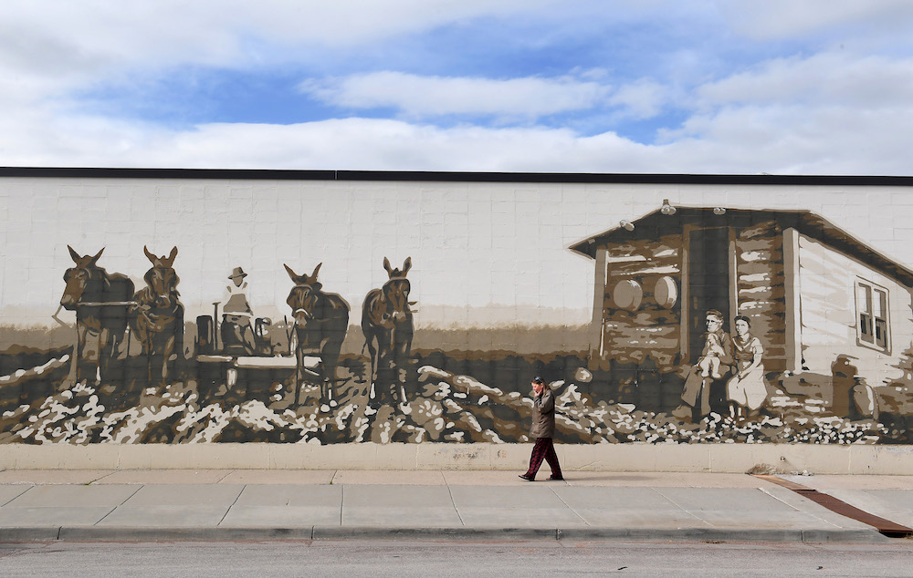 A pedestrian walks by a mural on the side of a building in Gillette, Wyoming. The area is a large—though declining—producer of coal, and Gillette calls itself "The Energy Capital of the Nation"
