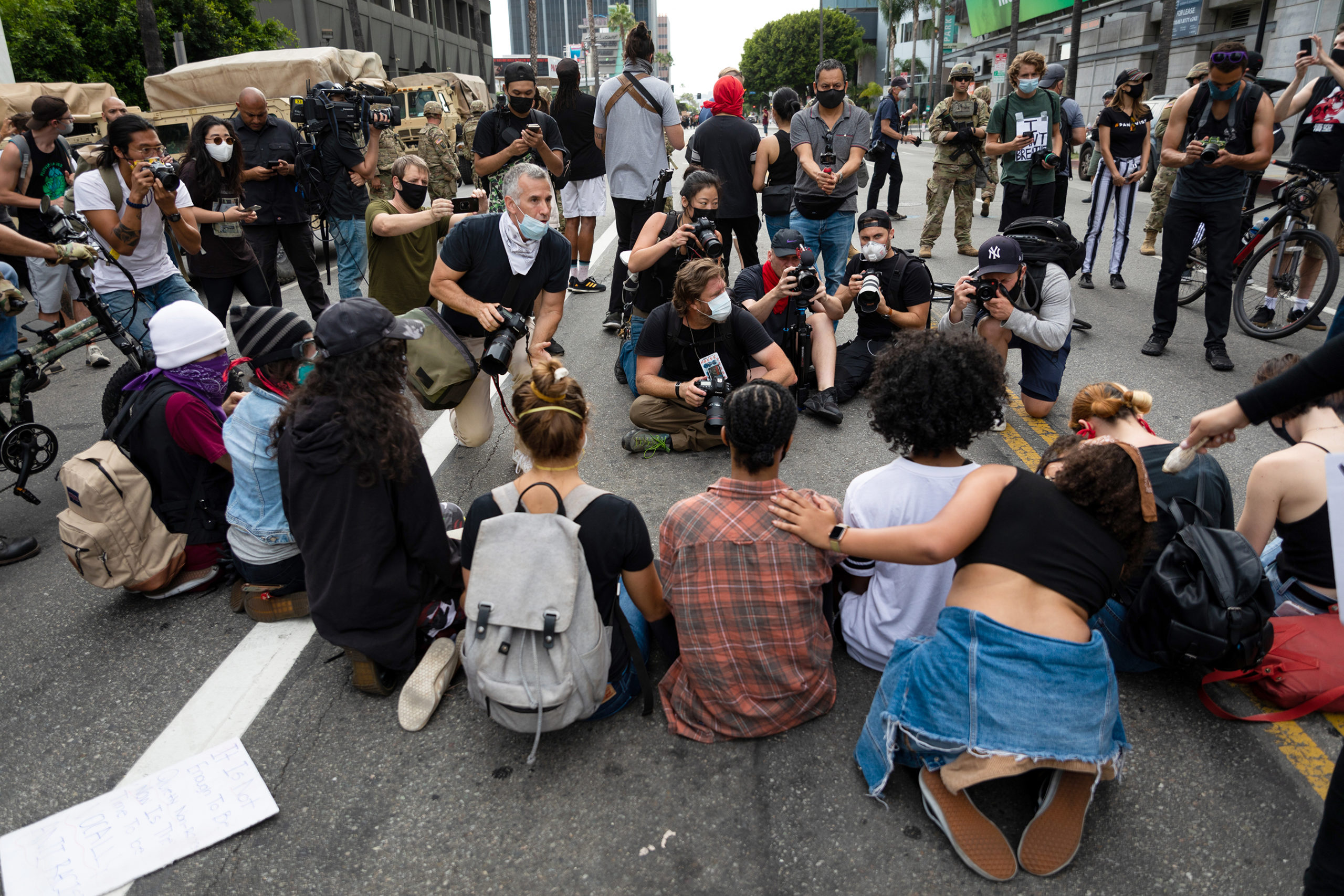 Photographers gather around a line of protestors