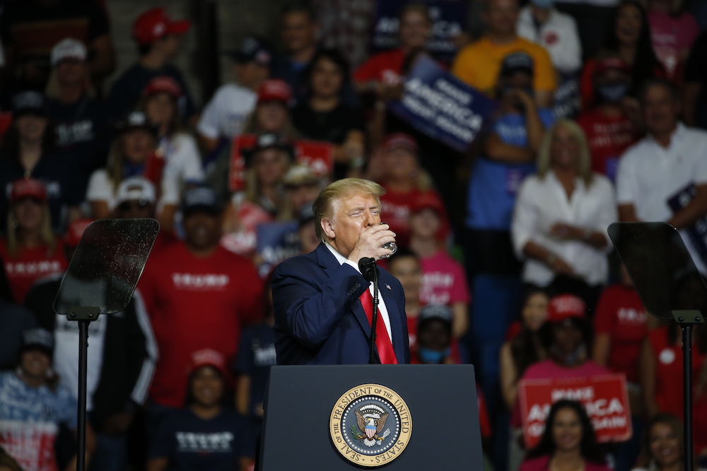 President Donald Trump drinks water during a campaign rally at the BOK Center Tulsa, Oklahoma in June 2020