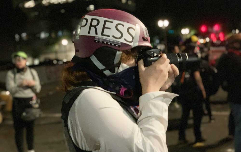 Eddy Binford-Ross takes a photo during protests in Portland, Oregon