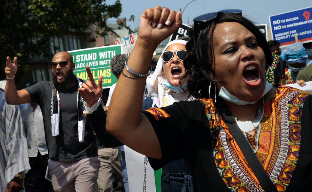 March organizers Marilyn Aleem-Shamikh, right, and Moji Sidiqi, center, chant for justice as they march with about 100 other Muslims in a mosque-to-mosque rally in support of the Black Lives Matter movement in St. Louis