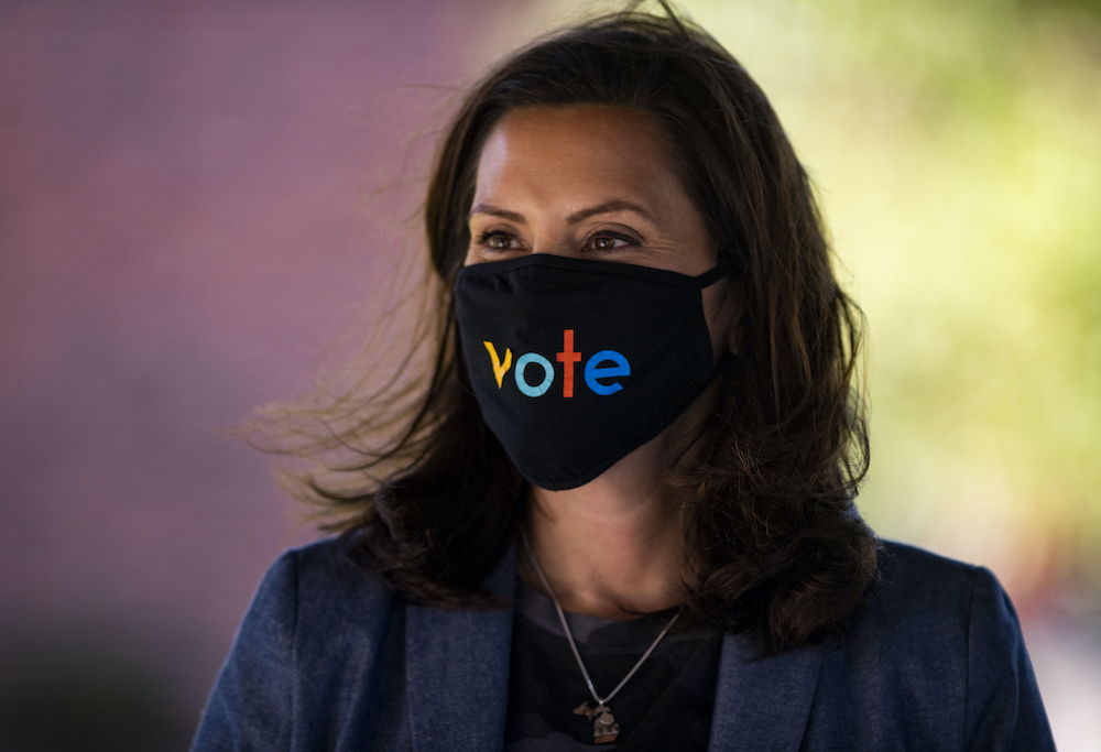 Michigan governor Gretchen Whitmer, pictured in October 2020, wears a mask with the word "vote" displayed on the front 