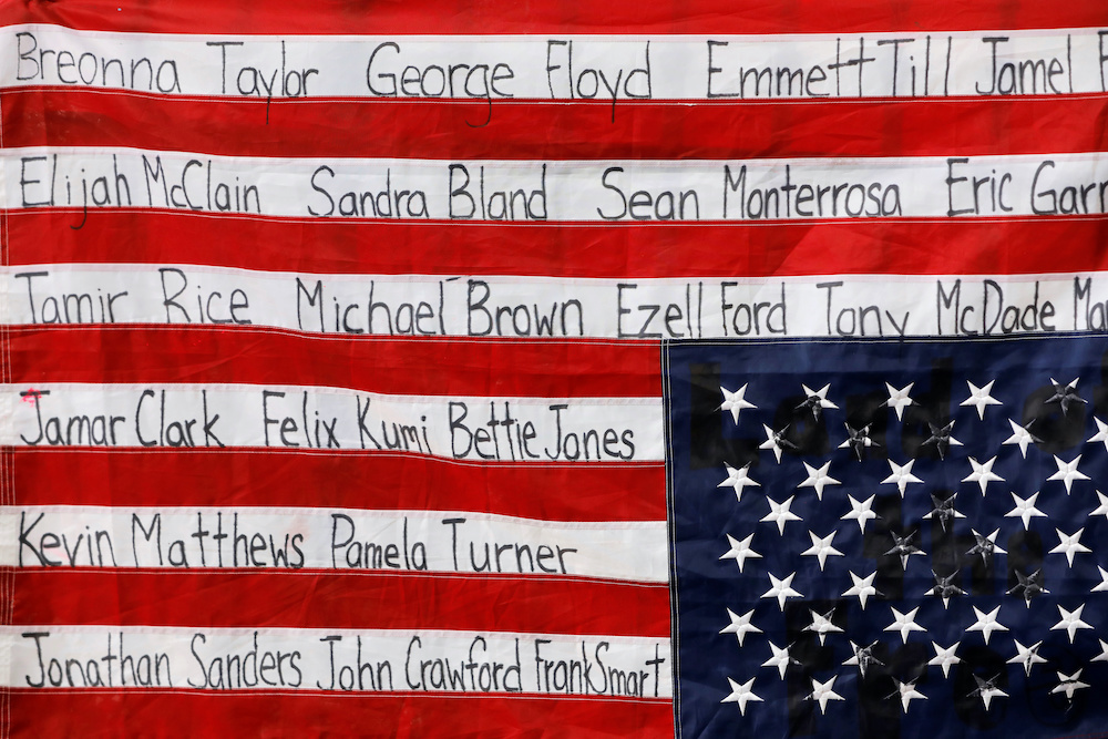 American flag featuring names of people killed by police.