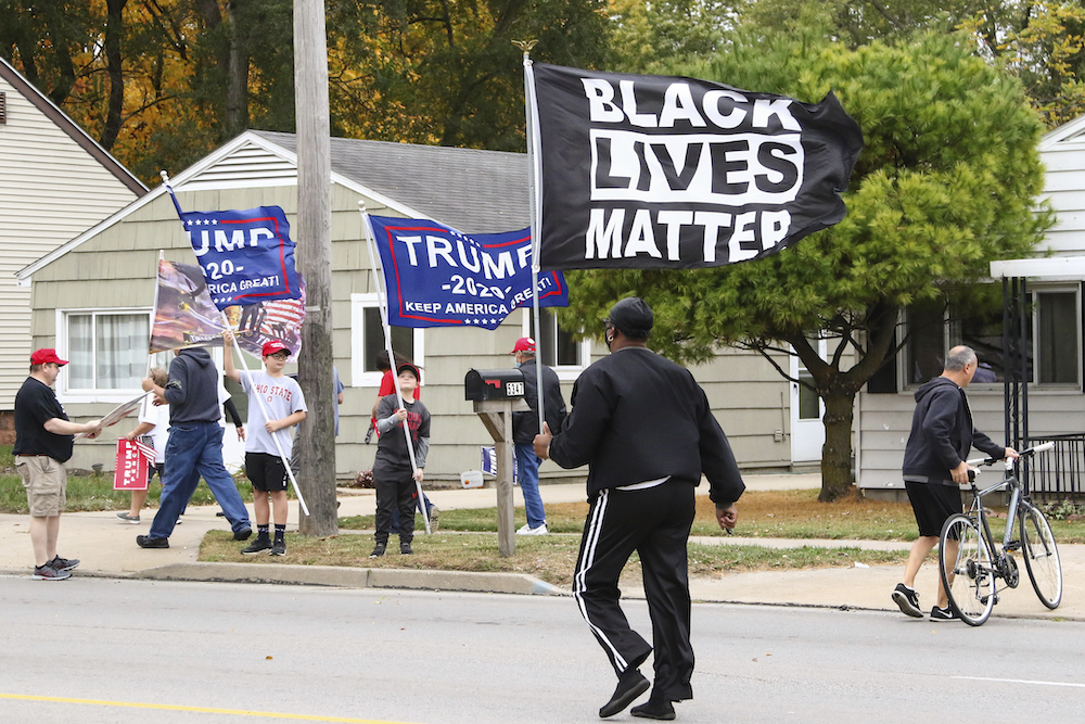 A man walks with a Black Lives Matter flag along the road at the conclusion of a campaign rally by former Vice President and Democratic presidential nominee Joe Biden on October 12, 2020, in Toledo, Ohio.