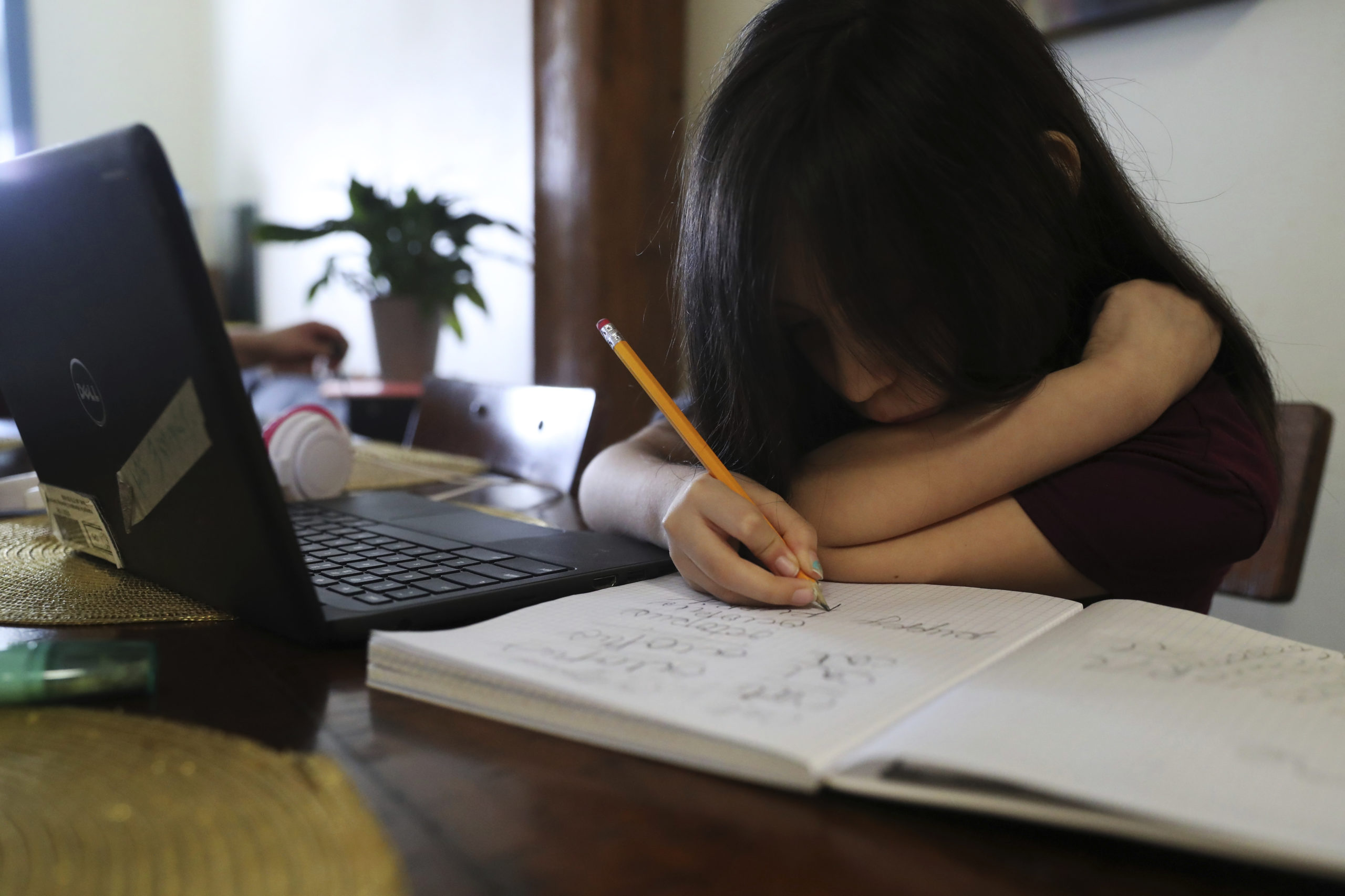 A young girl finishes her homework after her virtual school hours.