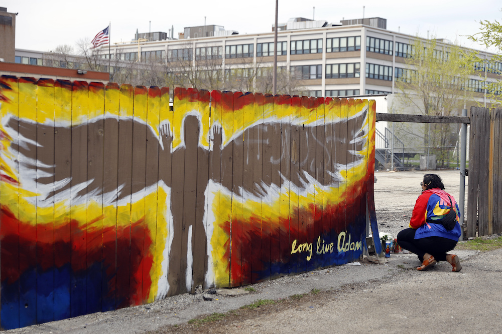 Andrea Fernanda Serrano kneels as she pays her respects at the site where 13-year-old Adam Toledo was shot by police, now marked with a mural in the Little Village neighborhood of Chicago on Friday, April 16, 2021
