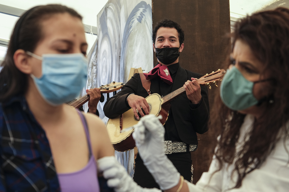 Members of Mariachi Serenade perform as a woman receives a vaccine for COVID-19 at a vaccination site run by CHIRLA, the Coalition for Humane Immigrant Rights, and the Mexican Consulate, in Los Angeles, Saturday, May 8, 2021.