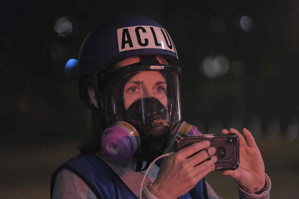 An ACLU legal observer films the scene as federal officers launch crowd control munitions to disperse protesters after the fence blocking access to the federal courthouse was torn down in Portland, Ore., on July 26, 2020