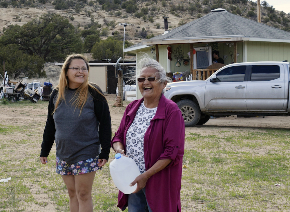 Wynice Franklin, left, and her mother Louise Johnson, right, receive bottled water from local officials in Church Rock, N.M., on the Navajo Reservation, during the Covid-19 pandemic on April 24, 2020
