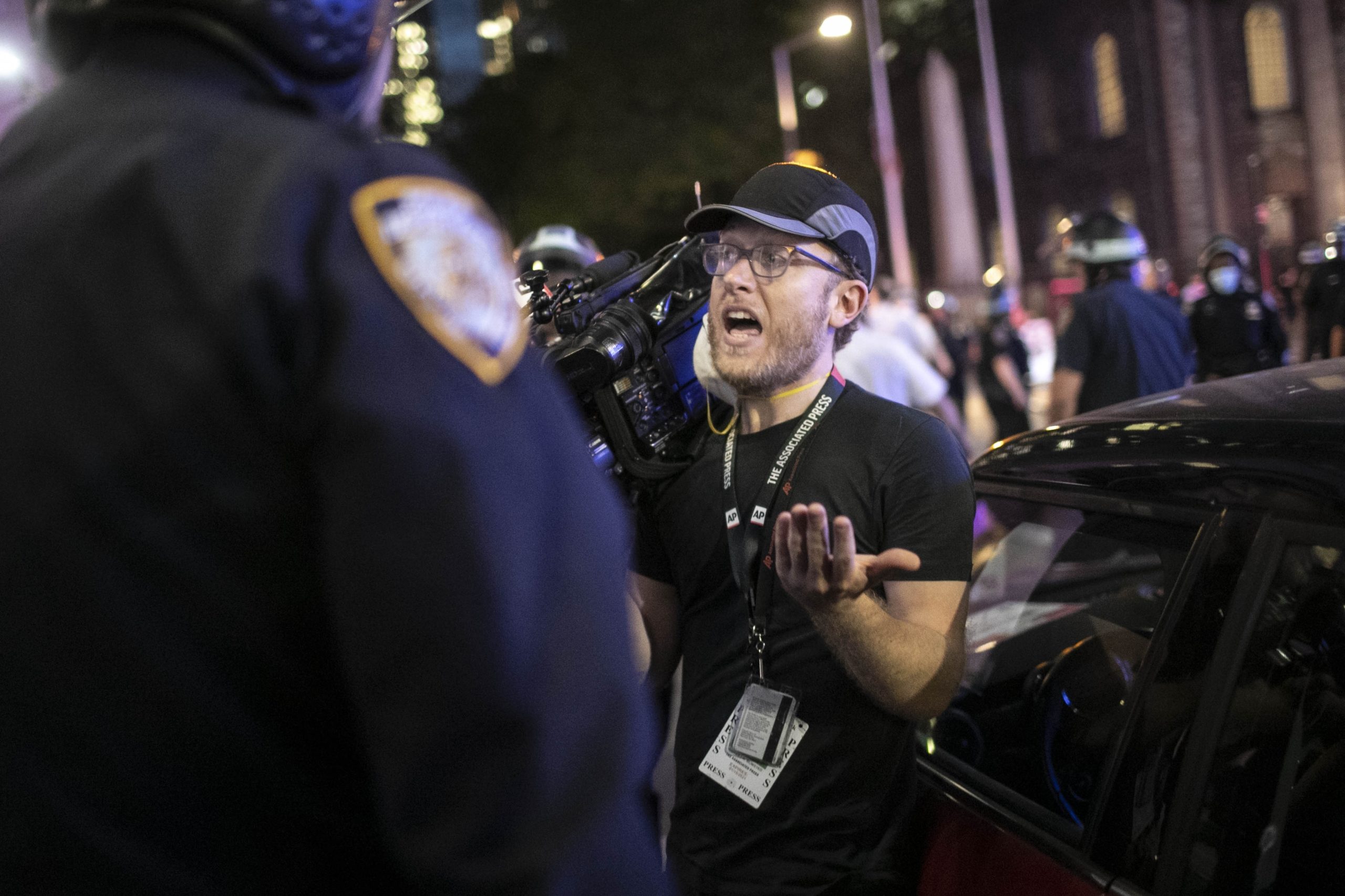 Associated Press videojournalist Robert Bumsted reminds a police officer that the press are considered “essential workers" and are allowed to be on the streets despite a curfew, Tuesday, June 2, 2020, in New York