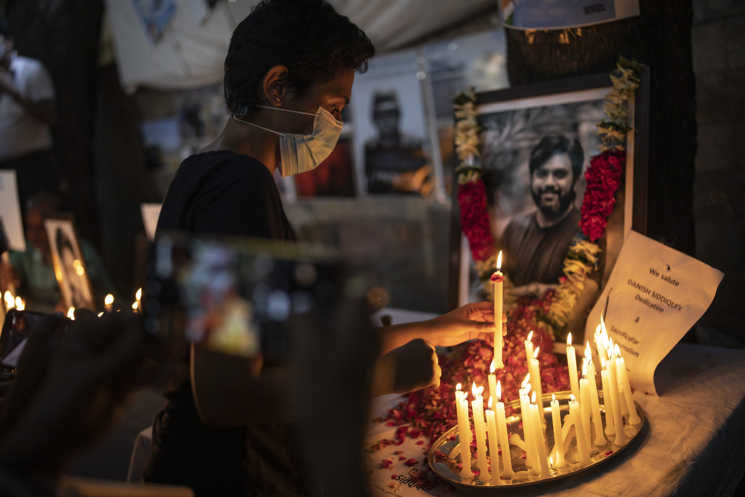 Journalists light candles and pay tribute to Reuters photographer Danish Siddiqui in New Delhi, India, Saturday, July 17, 2021. The Pulitzer Prize-winning photographer was killed as he chronicled fighting between Afghan forces and the Taliban