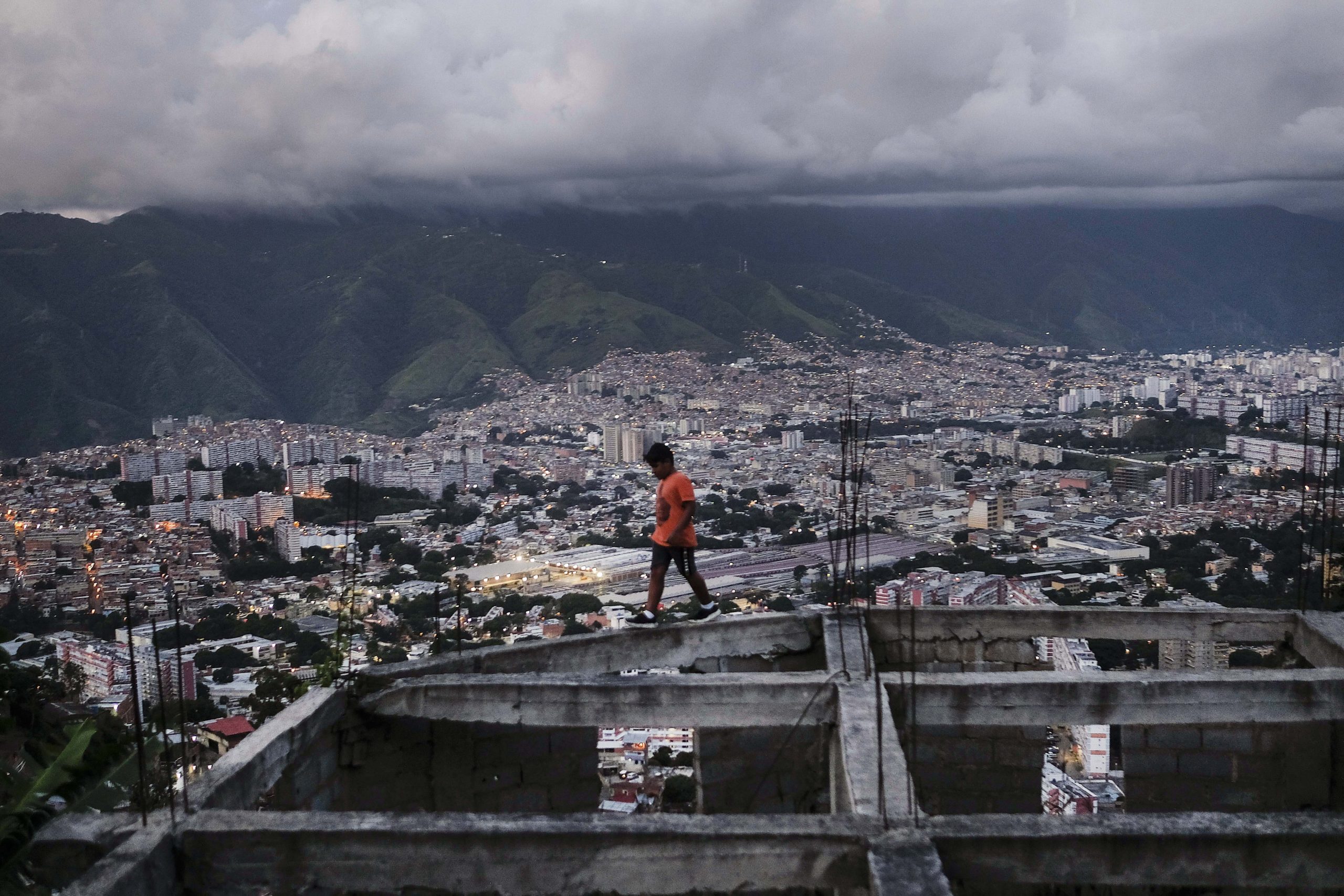 A boy walks on an unfinished house in the El Quilombo neighborhood of Caracas, Venezuela