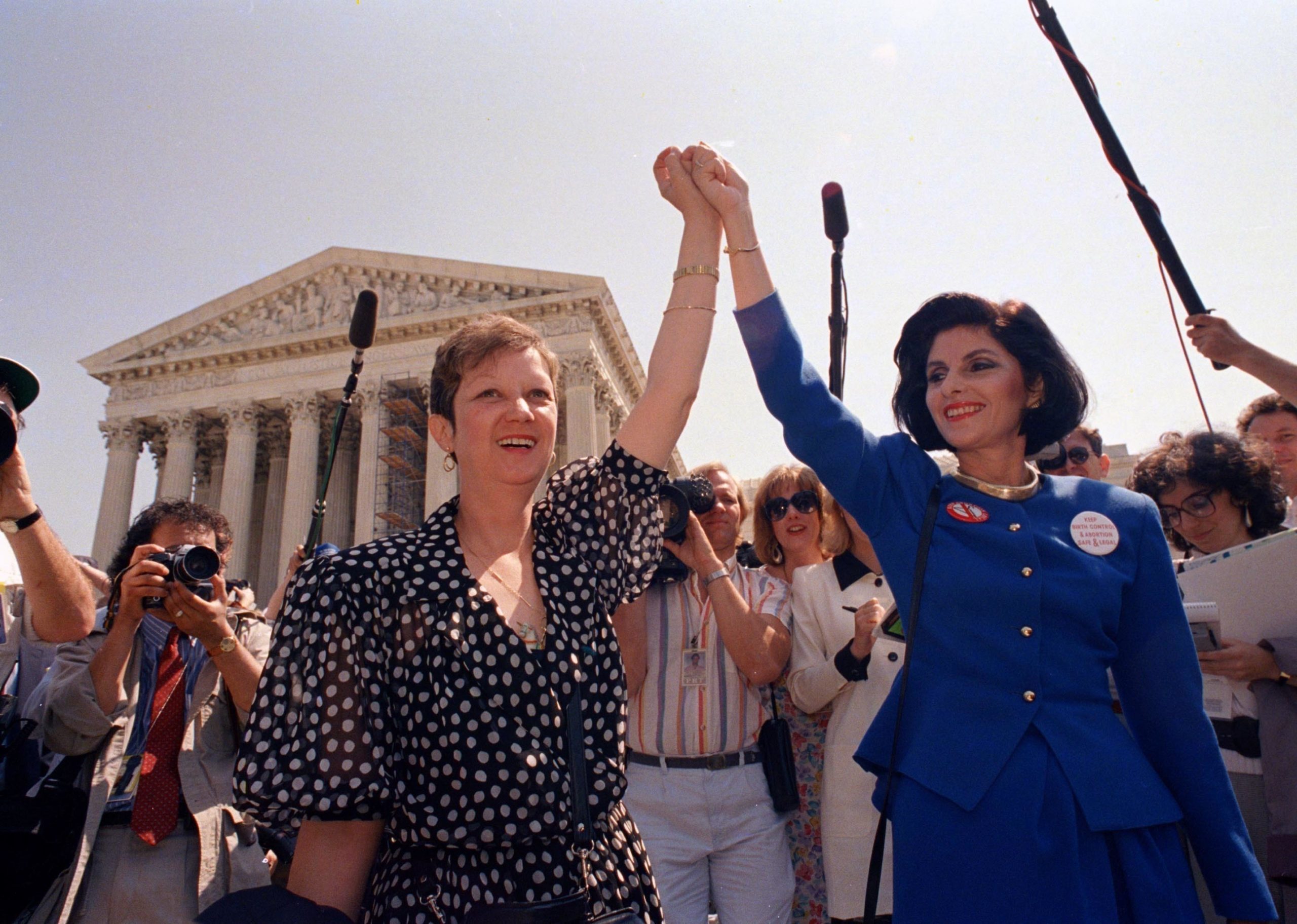 Norma McCorvey, better known as Jane Roe in the 1973 court case Roe v. Wade, left, and her attorney Gloria Allred hold hands as they leave the Supreme Court building in 1989. In "The Family Roe," Joshua Prager shines a new light on McCorvey's life and legacy