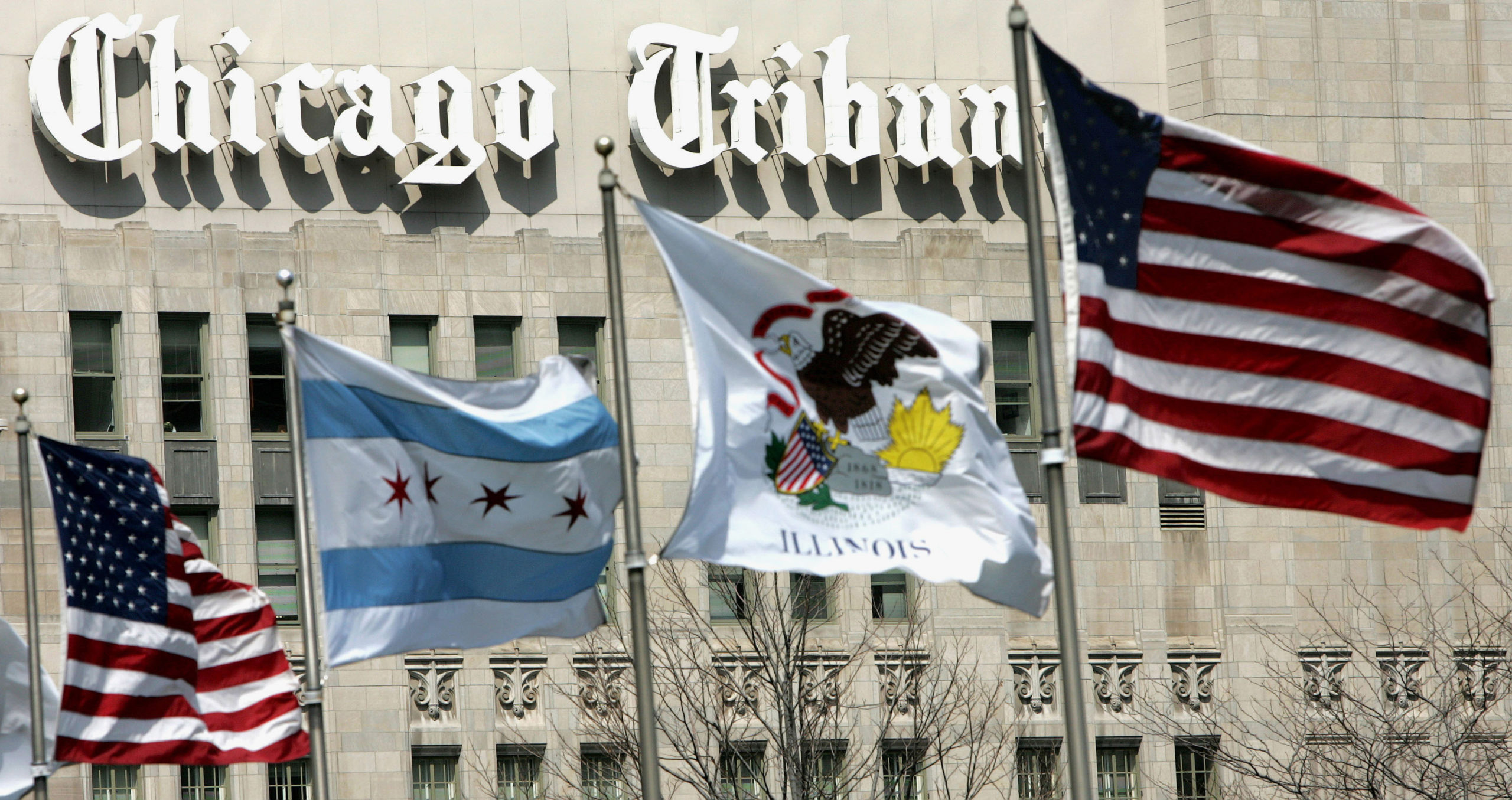 Flags wave near the Chicago Tribune Tower. Newspaper publisher Tribune agreed to be sold to Alden Global Capital, a hedge fund known for cutting costs, in Feb. 2021. As hedge funds slash staff positions, some newsrooms have unionized in response