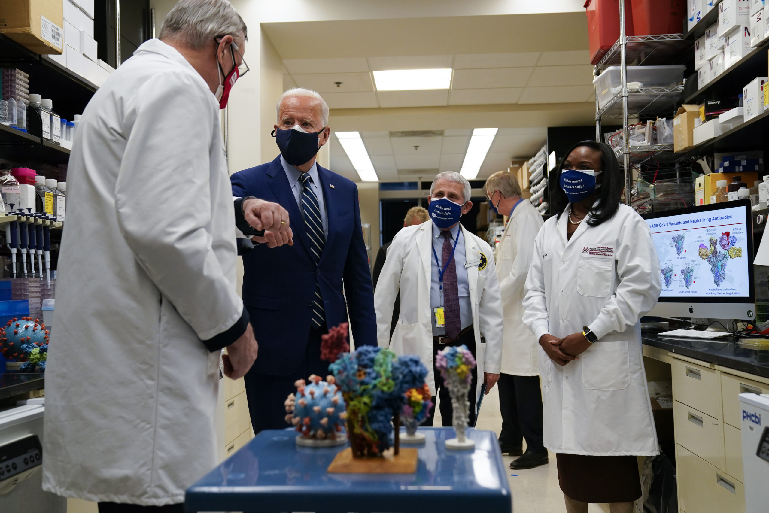 President Joe Biden greets Barney Graham, left, as he visits the Viral Pathogenesis Laboratory at the National Institutes of Health in Feb. 2021
