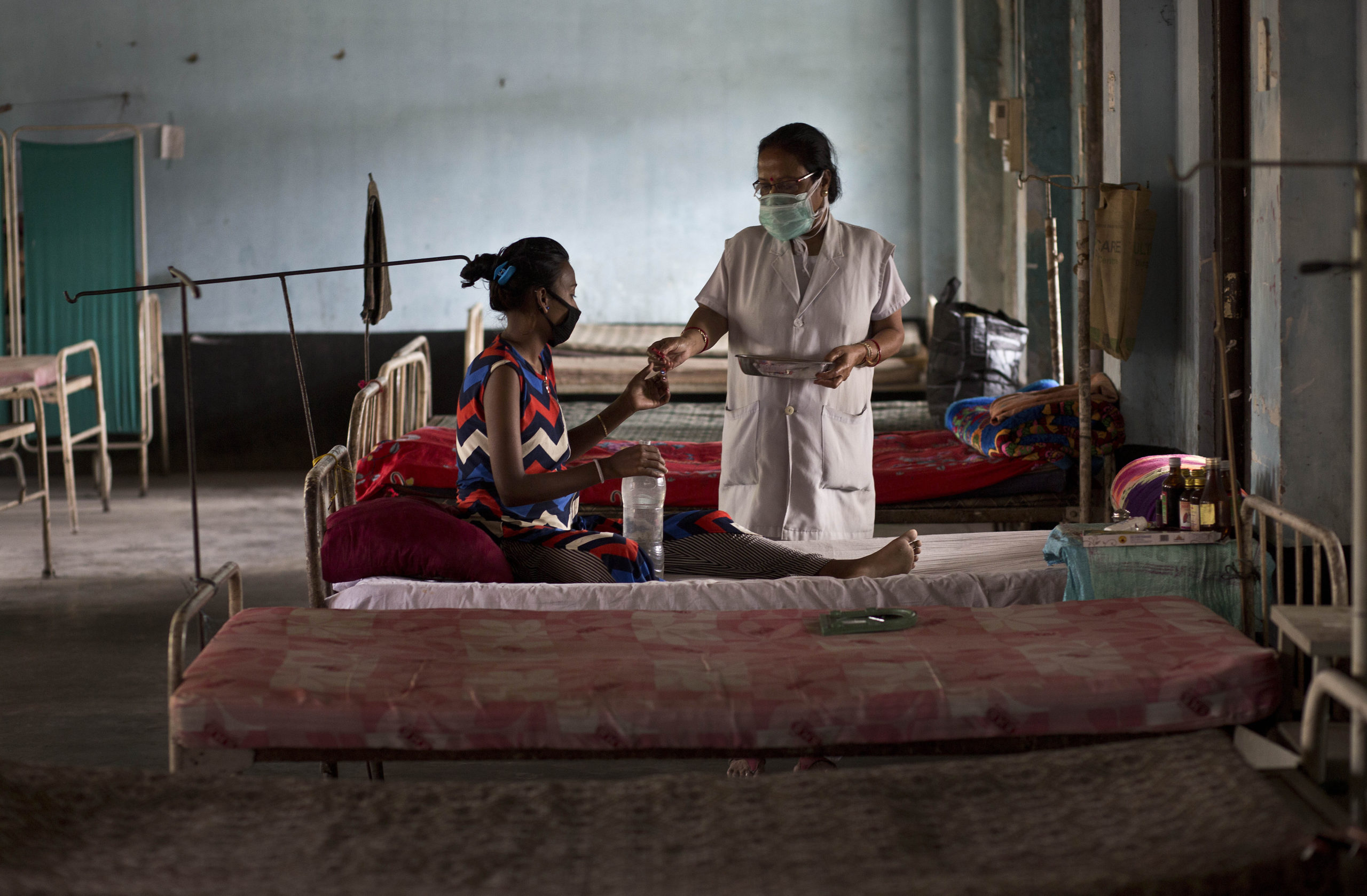 An Indian tuberculosis patient receives medicines from a nurse at a TB hospital in Gauhati, India