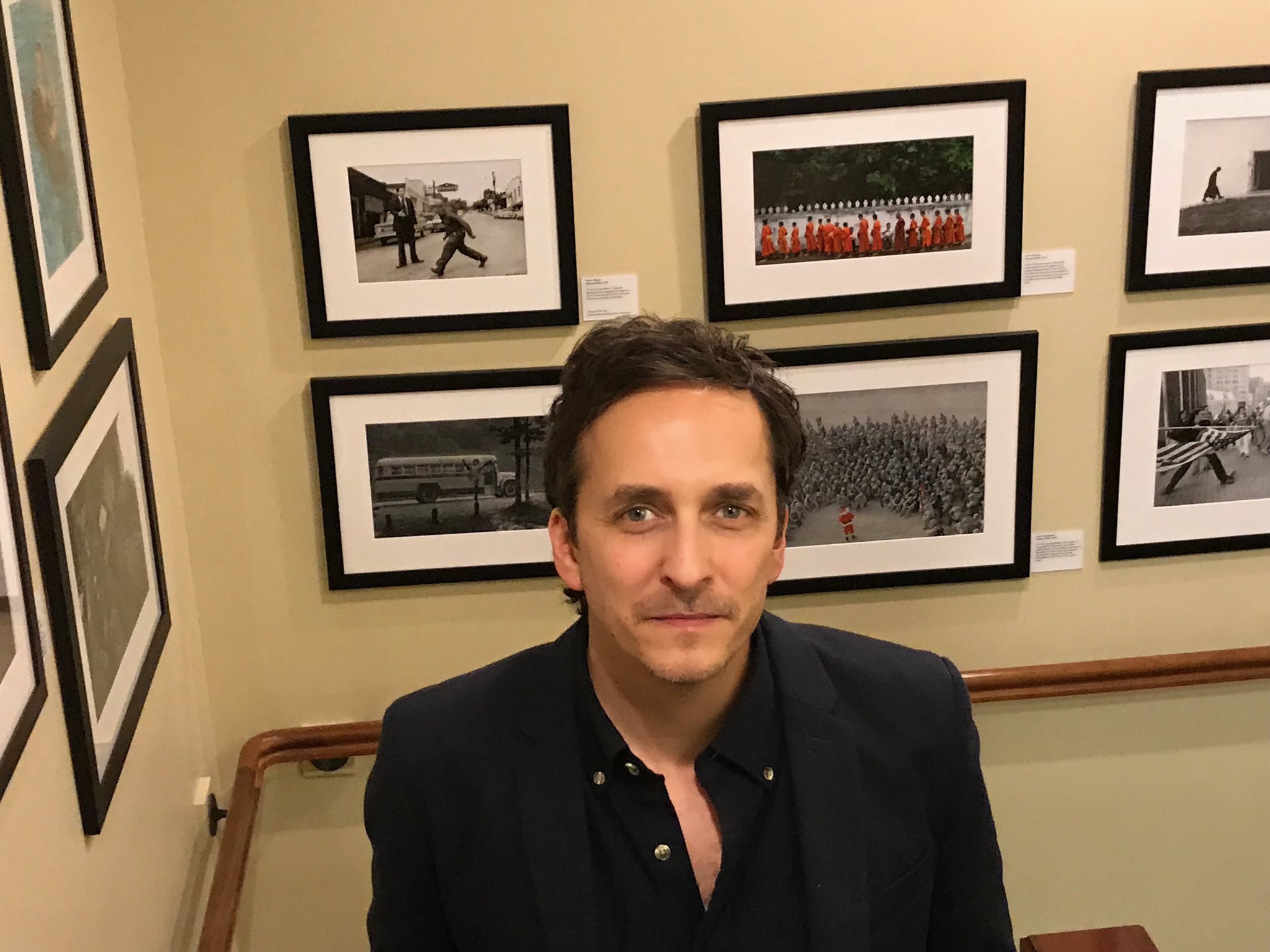 Brent Renaud standing in front of photos at the Nieman Foundation for Journalism at Harvard