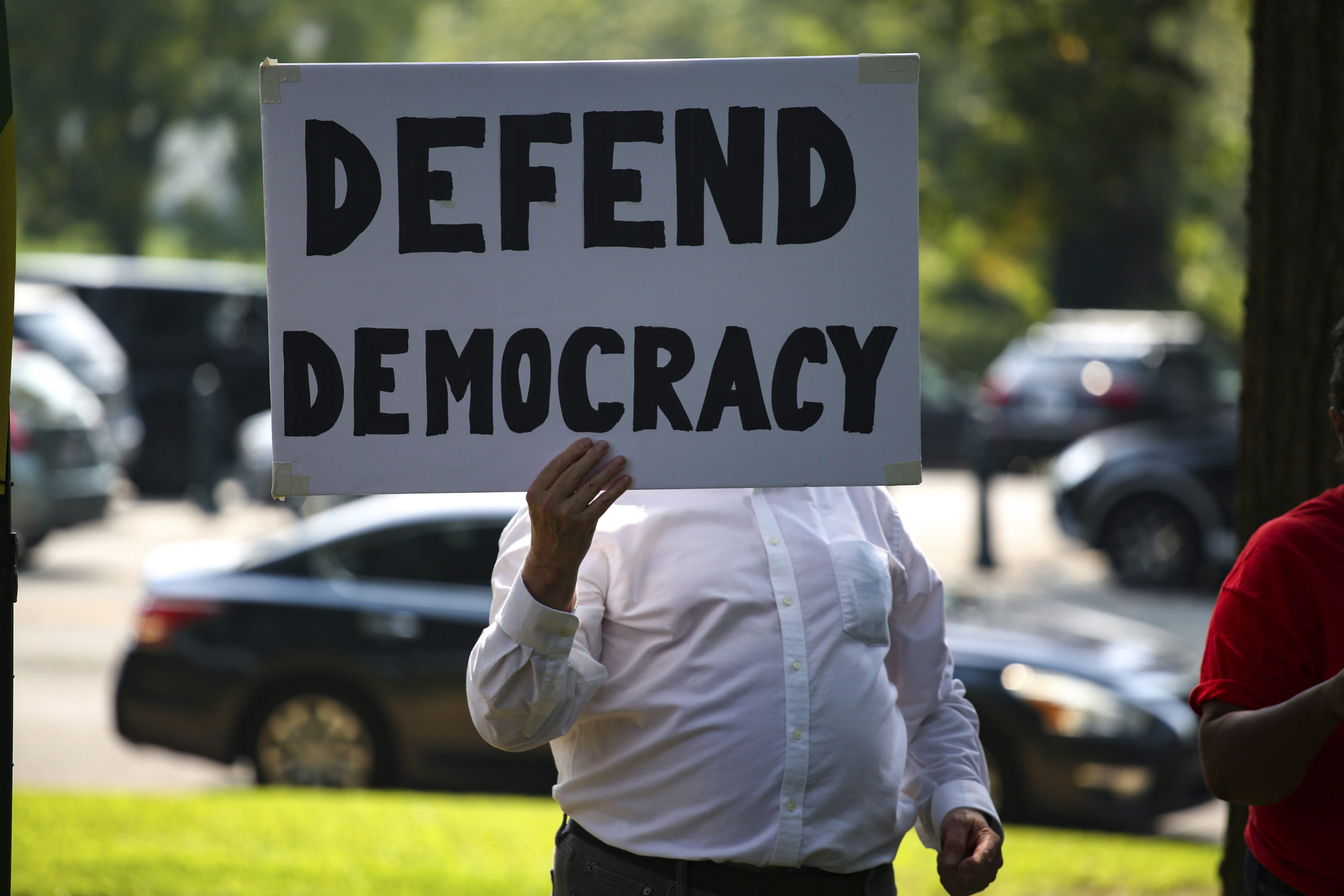 People watch and hold signs as members of Congress speak at a voting rights rally near U.S. Senate office buildings in Washington, D.C. on September 14, 2021 