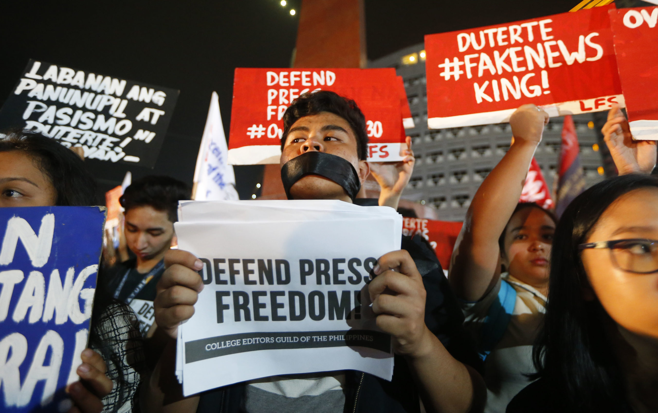 Journalists and supporters display their messages during a protest against the recent Securities and Exchange Commission's revocation of the registration of Rappler, an online news outfit, northeast of Manila, Philippines, Jan. 2018 