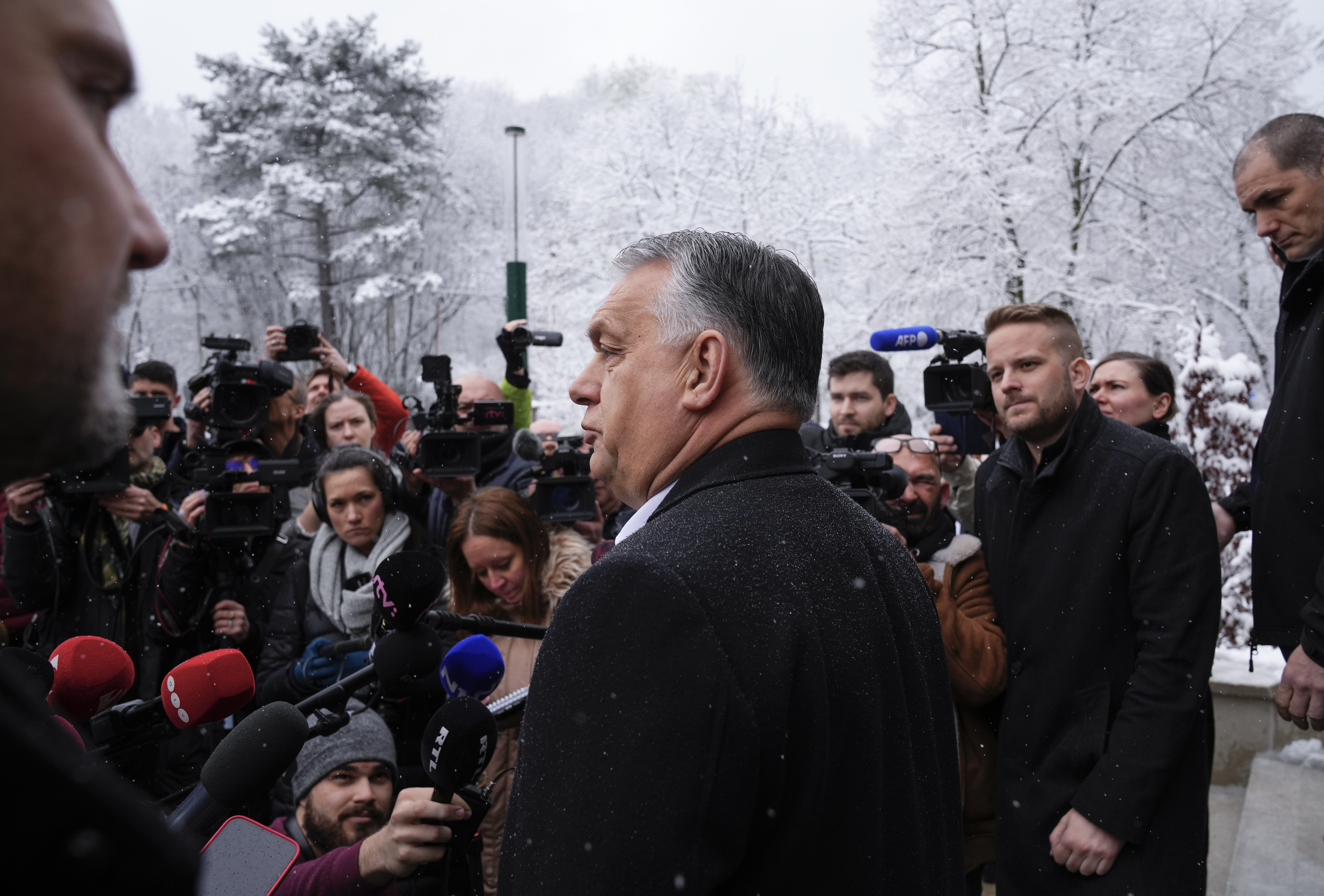 Hungary's nationalist prime minister Viktor Orbán, center, talks to the media after casting his vote in the general election in Budapest, Hungary, April 3, 2022