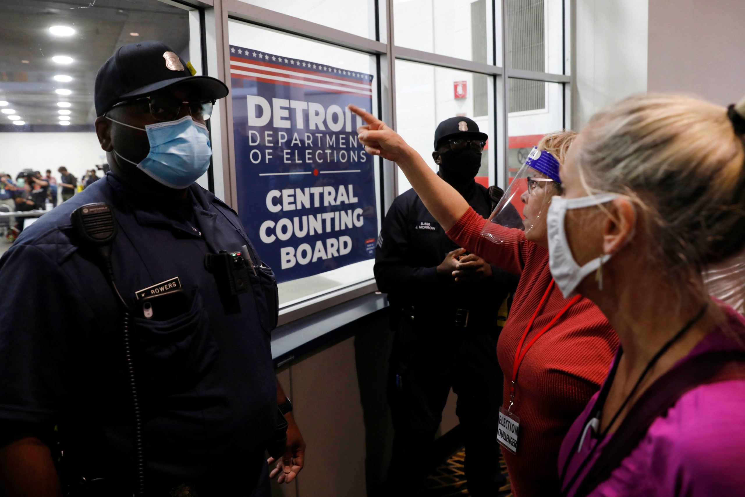 Police officers face supporters of Donald Trump as they chant slogans outside the room where absentee ballots for the 2020 general election are being counted at TCF Center on November 4, 2020 in Detroit, Michigan.