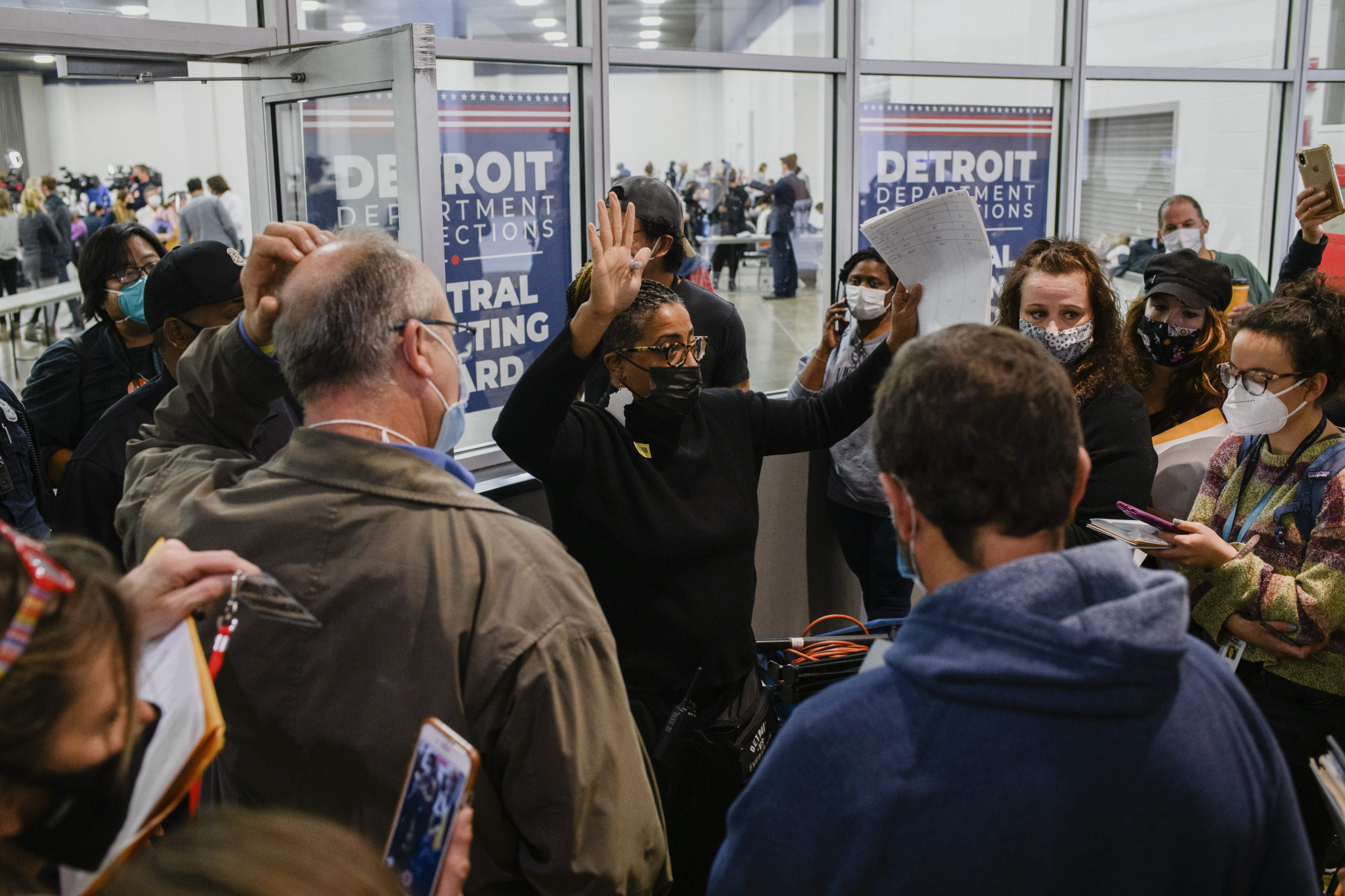 A Detroit Department of Elections worker pushes the crowd back as absentee ballots are counted on Nov. 4, 2020.