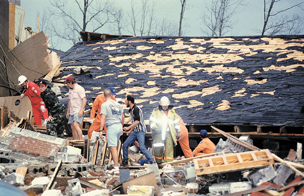 a group of workers search in rubble after a tornado swept through and leveled a church