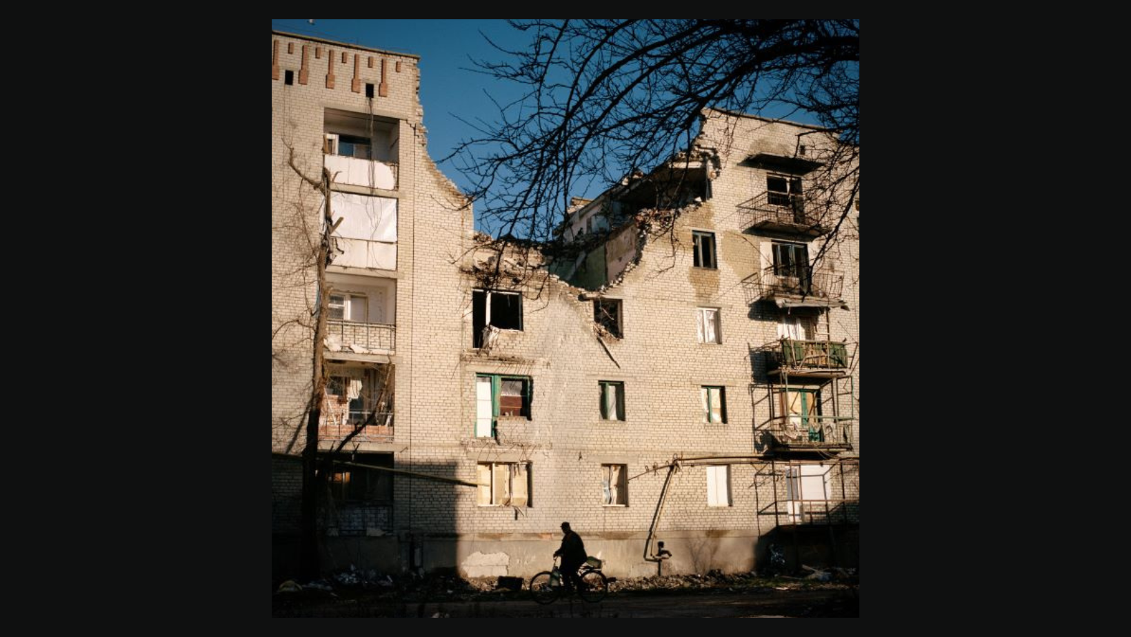 a building, damaged by bombing, shines in the light