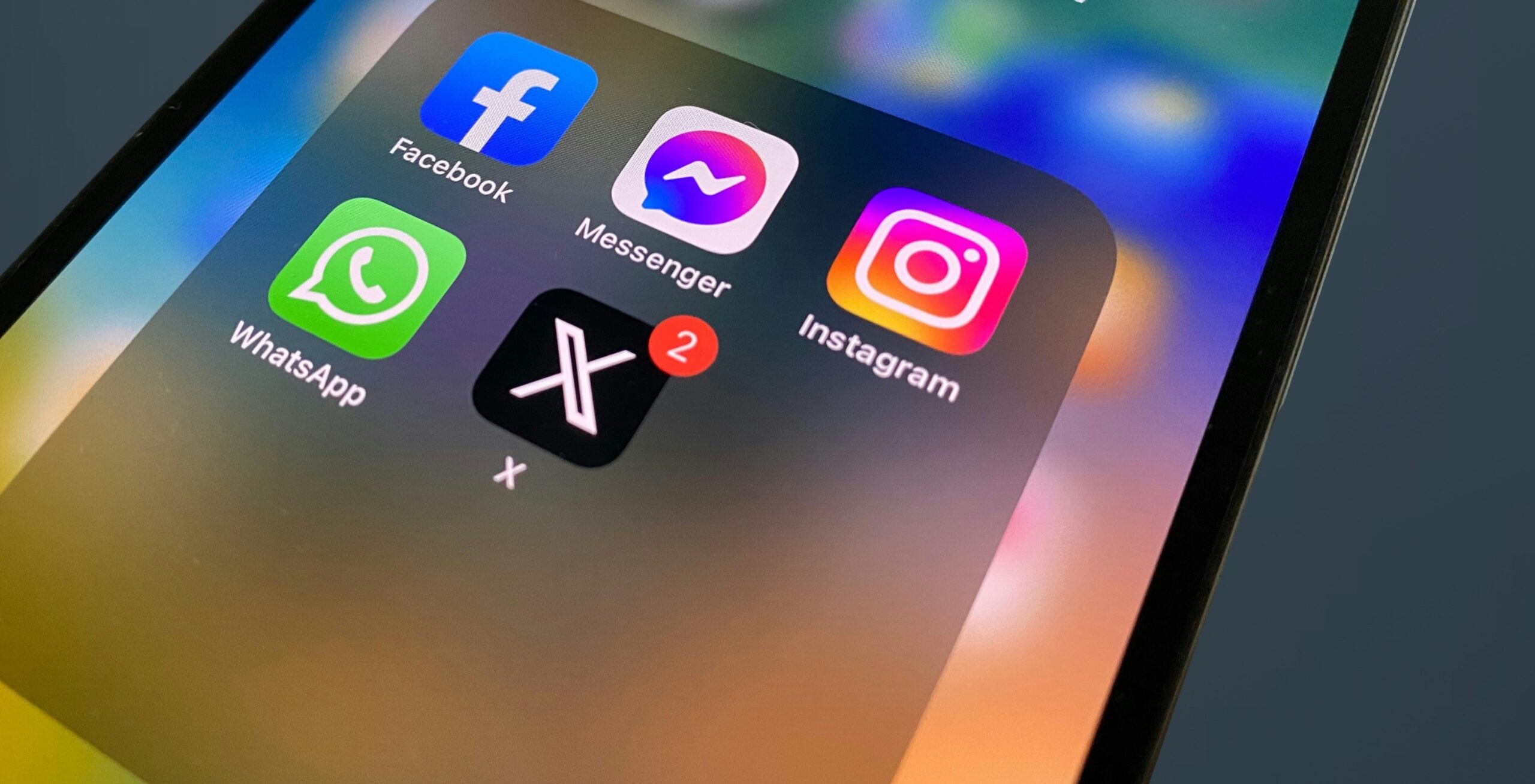 photo of an iphone with the facebook, messenger, instagram, whatsapp, and X icons